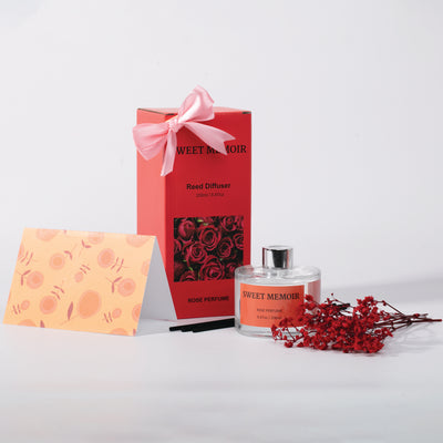 Sweet Memoir gift set featuring reed diffuser and essential oils in a festive red box with a pink ribbon, perfect for gifting.