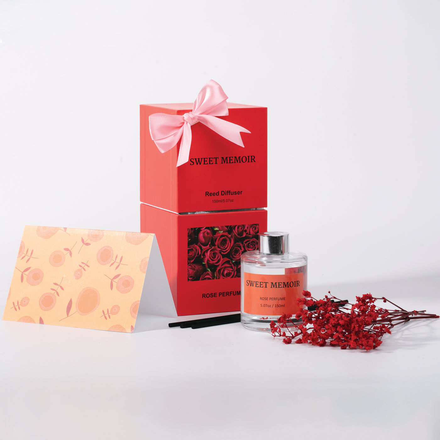 Sweet Memoir gift set featuring reed diffuser and essential oils in a festive red box with a pink ribbon, perfect for gifting.